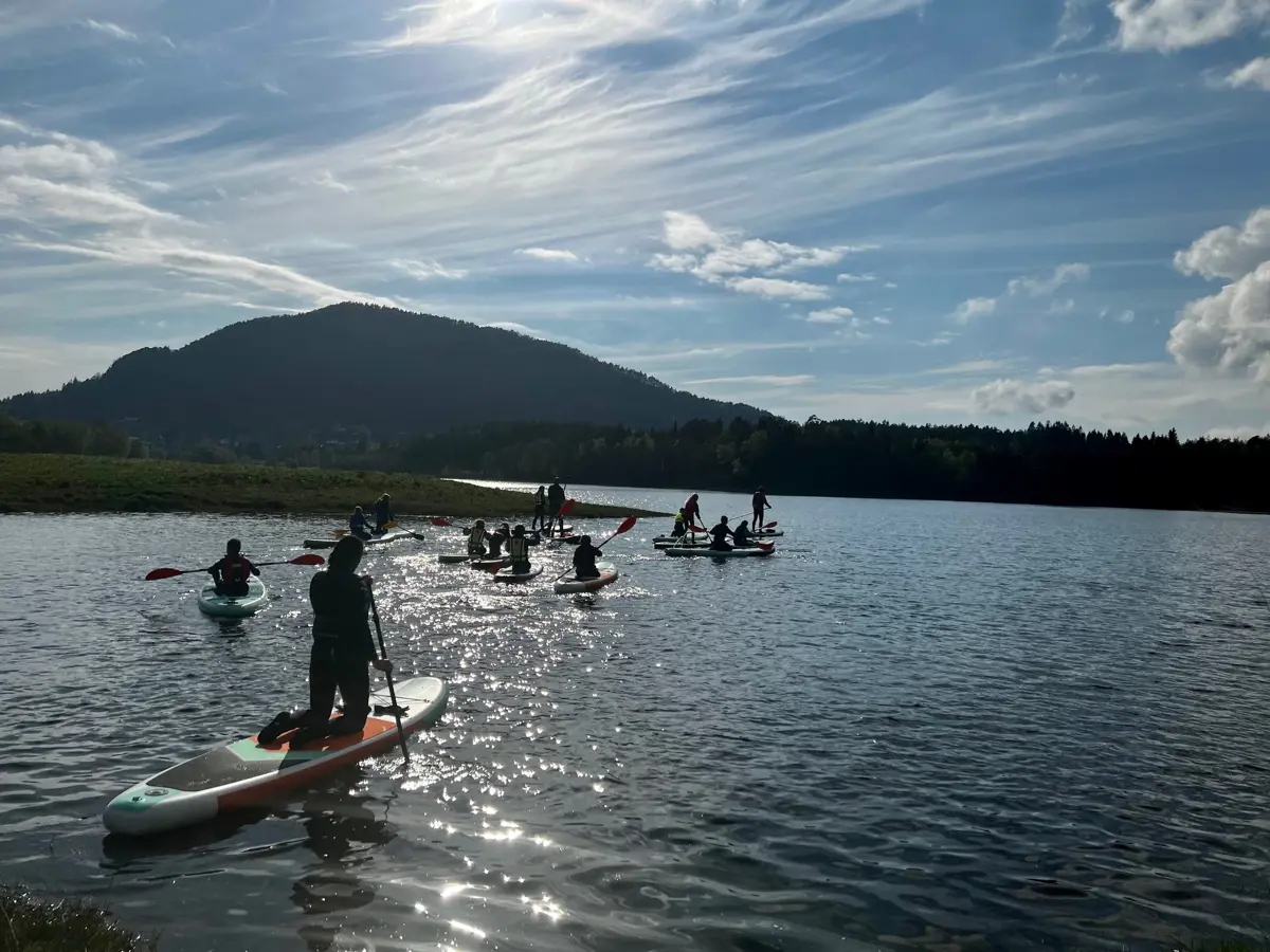 Barn og unge på padlebrett på Tøsdalsvatnet i fint sommarvær