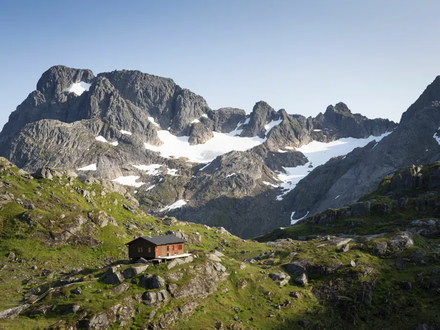 Hytte mellom høye fjell 