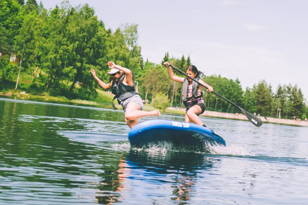 Ungdommer i packraft på stille vann