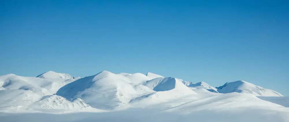 Snødekte fjelltopper og blå himmel