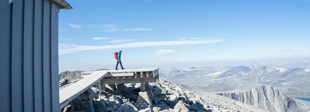 Person som står på en bygget plattform på en fjelltopp
