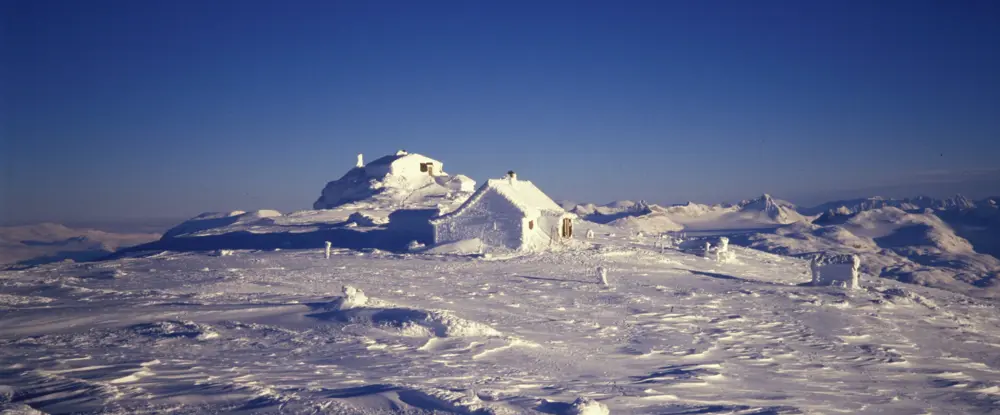 Fannaråkhytta helt dekket i snø etter en snøstorm.