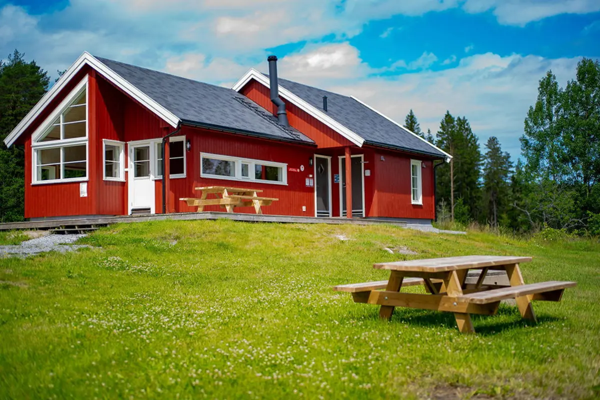 Østtorphytta og sitteplassene foran hytta. Foto.