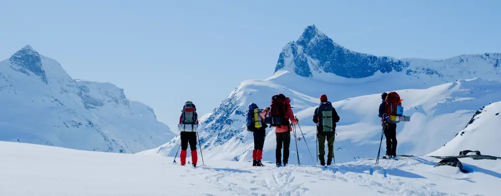Flere personer med fjell som ser på en fjelltopp