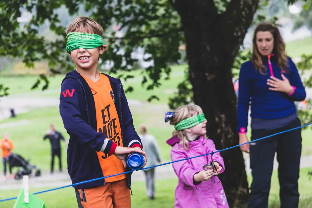 Barn med bind for øynene kjenner på gjenstander på tau