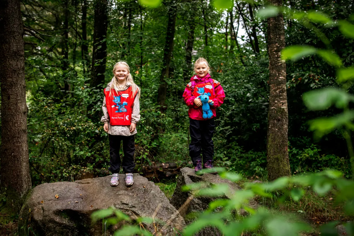 To jenter på stein i skogen.