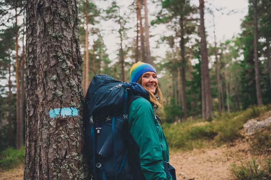 Kvinne med stor sekk i skogen