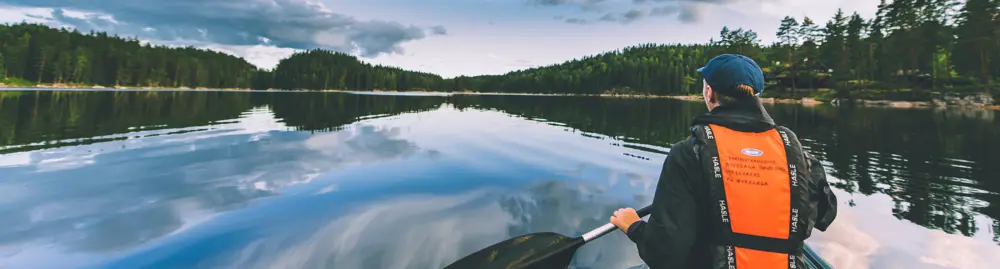 Person i kajakk på skogsvann