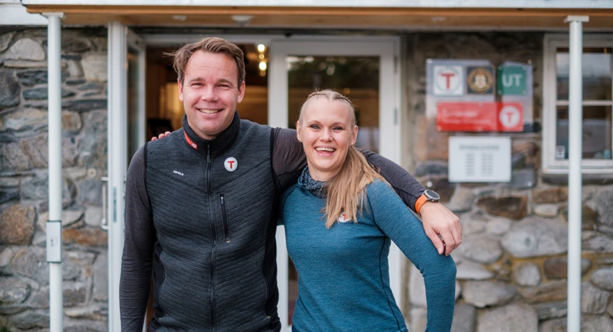 En mann og en kvinne holder rundt hverandre utenfor en inngang til et Tursenter.