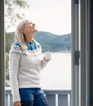 Agnethe Larsen drikker kaffe på terrassen på Nodhagen turisthytte, Sandnes. Kyst, kysthytte.