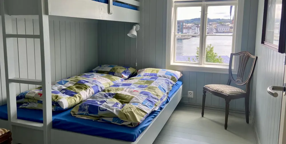 En rom med vindu og dobbeltseng. Foto. 