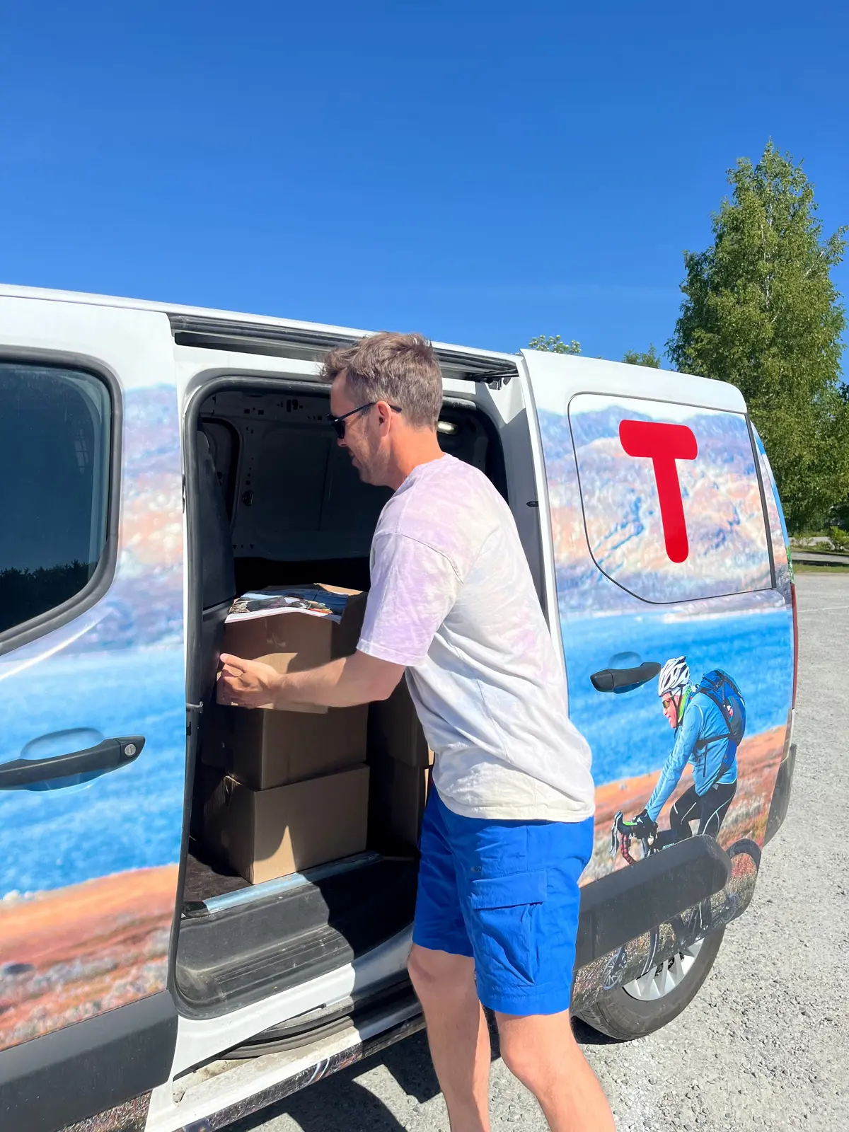 Thor Anders Fareid i DNT Telemark distribuerer Turglede fra DNT-bilen som er levert av Toyota Porsgrunn.