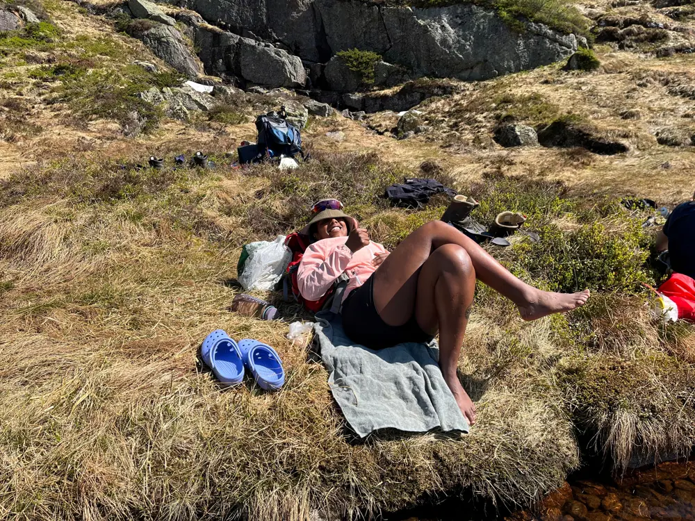 En dame ligger i gresset og soler seg.
