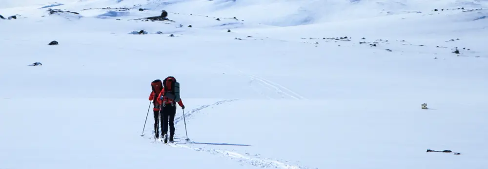 To personer som går på fjellski i fjellet