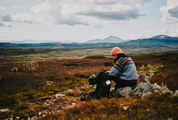 Lady with a orange hat walking in the mountains