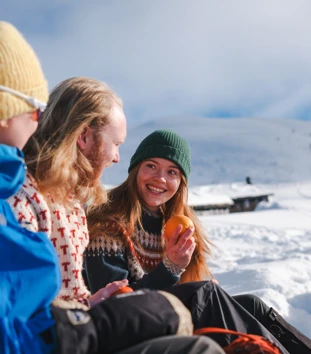 en gruppe mennesker som sitter på et snødekt fjell