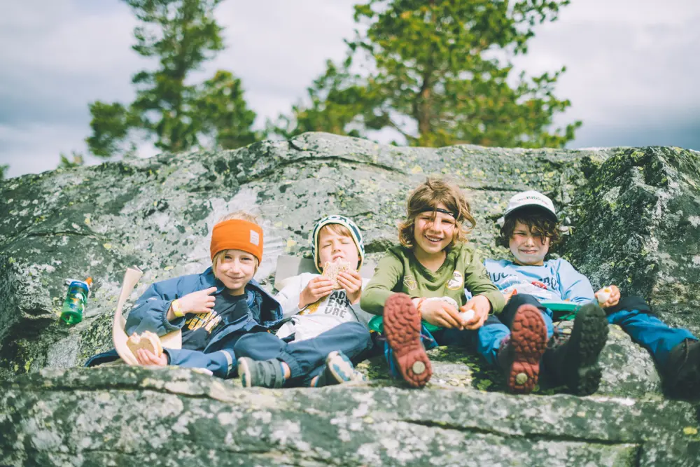 4 barn som sitter på en fjellhylle