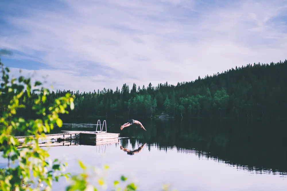 en person som stuper ned i en innsjø