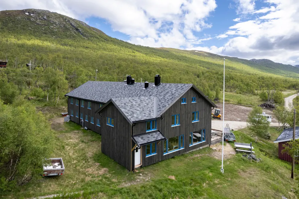 Grå hytte med gress rundt