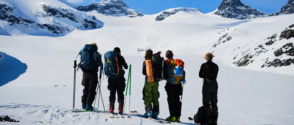 En gruppe skikjørere på et snødekt fjell