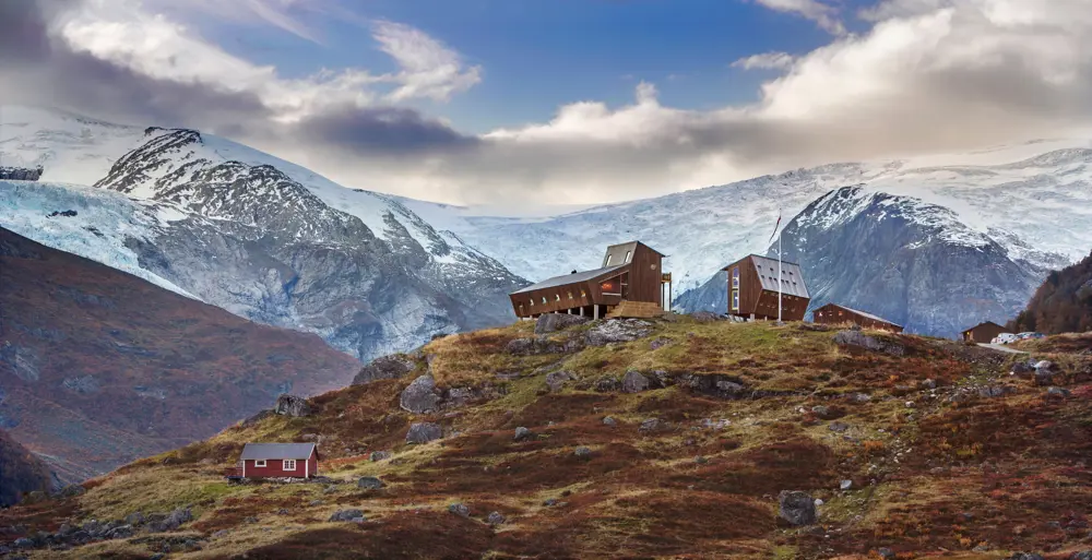 Bilder av moderne turisthytte med bre og fjell på alle kanter