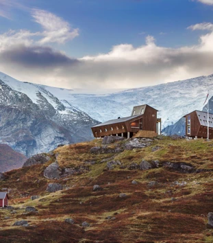 Bilder av moderne turisthytte med bre og fjell på alle kanter