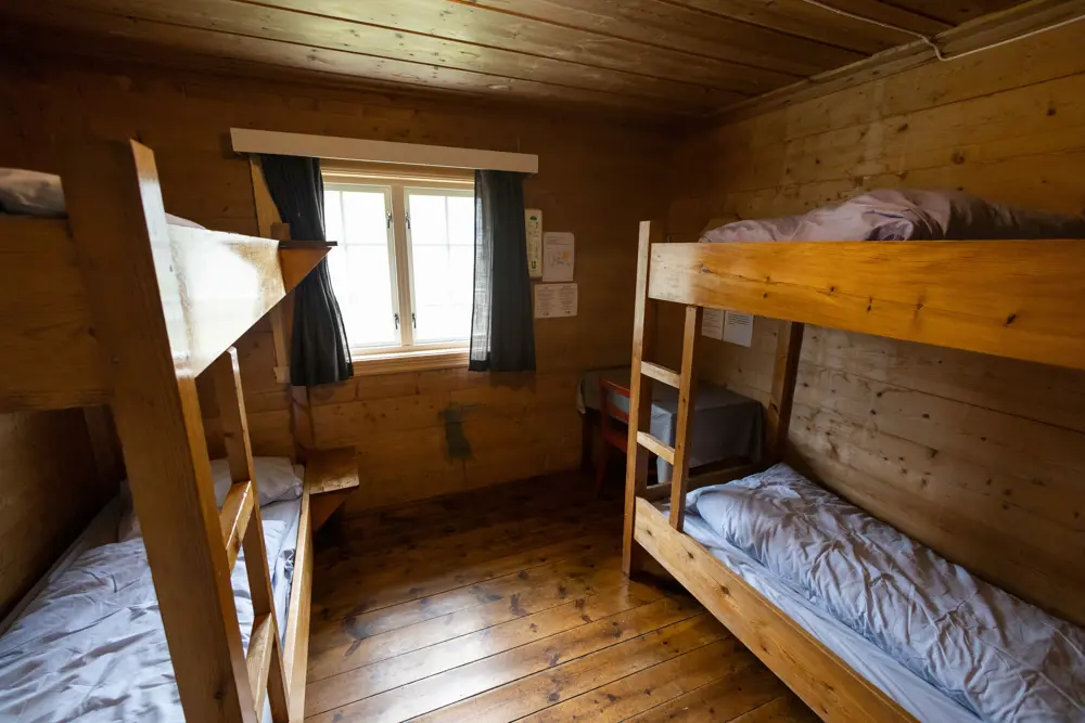 Soverom på hytte med furuvegger og to etasjesenger